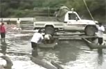 Cruzando camioneta por el rio en canoa